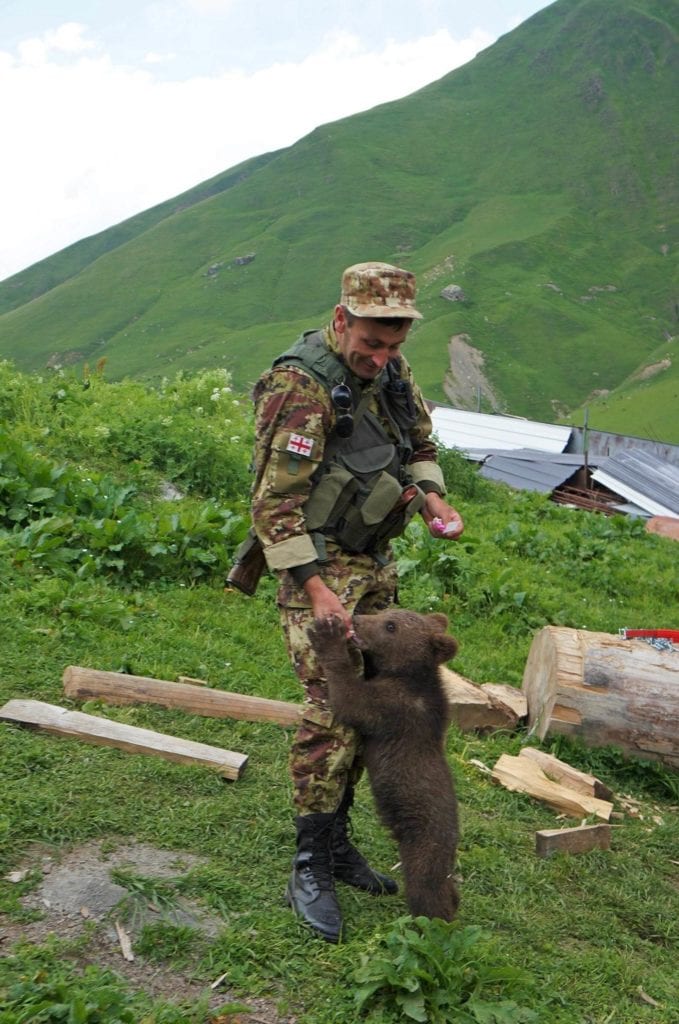 Gruziński strażnik graniczny z małym niedźwiedziem. Swanetia
